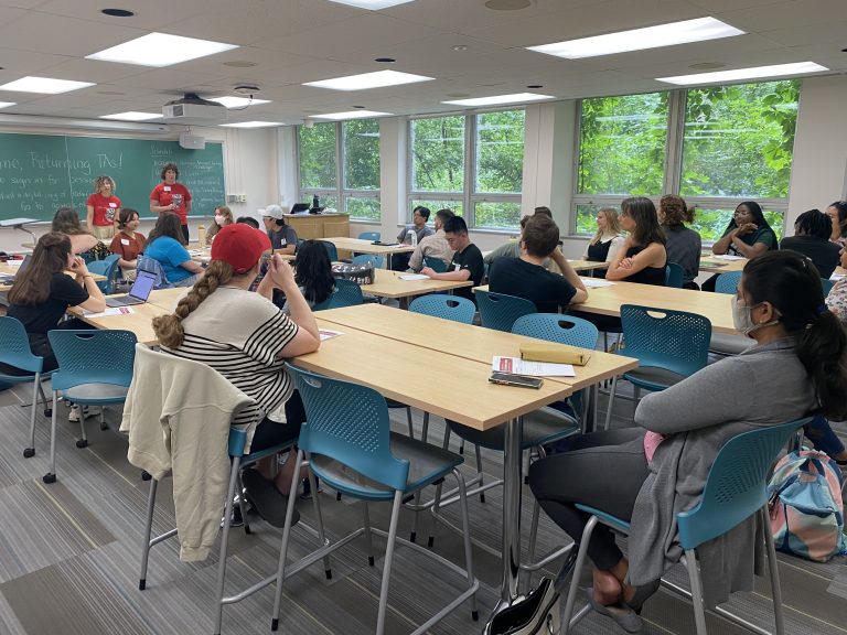 TAs working around tables in a classroom